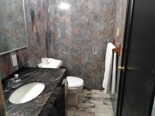 een badkamer met een wastafel en een toilet bij Gal - Habitaciones Confortables in Cuernavaca