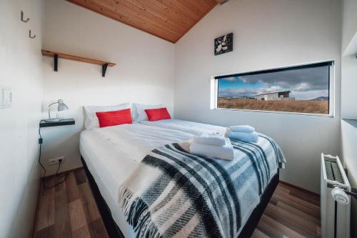 een kleine slaapkamer met een bed en een raam bij Blue View Cabin 6B With private hot tub in Reykholt