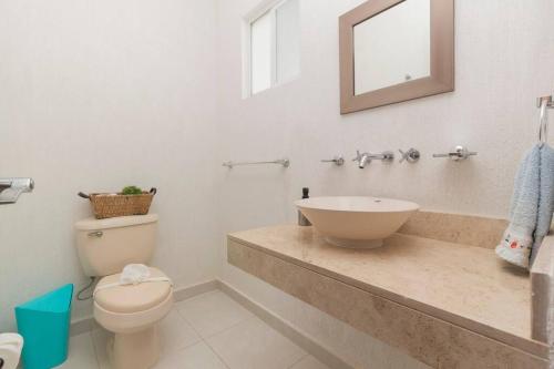a bathroom with a sink and a toilet and a mirror at Casa Bella in Playa del Carmen