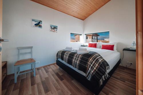 sypialnia z dużym łóżkiem z czerwonymi poduszkami w obiekcie Blue View Cabin 6A With private hot tub w mieście Reykholt