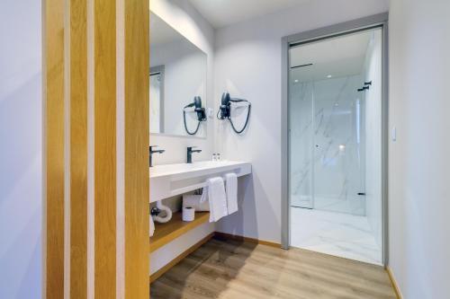 La salle de bains est pourvue d'un lavabo et d'une douche. dans l'établissement room Select Porto, à Porto