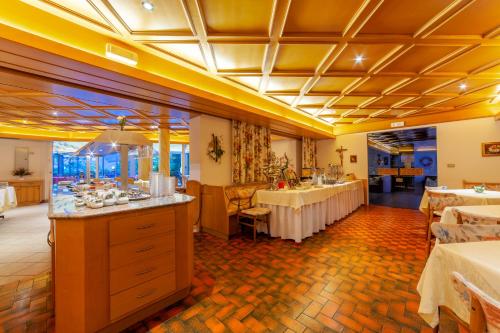 een restaurant met 2 tafels en een buffet bij Frühstücks-Hotel Olympia in Tirolo