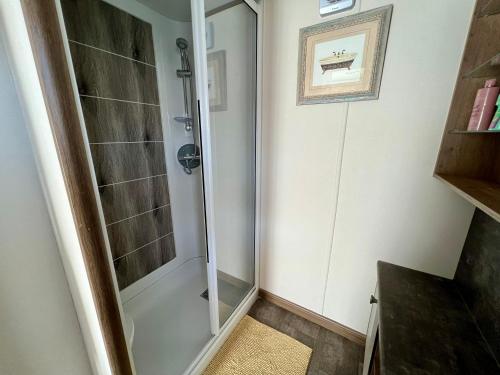 baño con ducha y puerta de cristal en Sunflower Hot Tub Lodge, en South Cerney