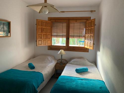 2 camas en un dormitorio con sábanas azules y ventana en Costa Hispania, en Gran Alacant