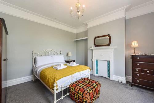 Schlafzimmer mit einem Bett, einer Kommode und einem Spiegel in der Unterkunft Traditional 3-Bed Property in Pontcanna with Parking in Cardiff