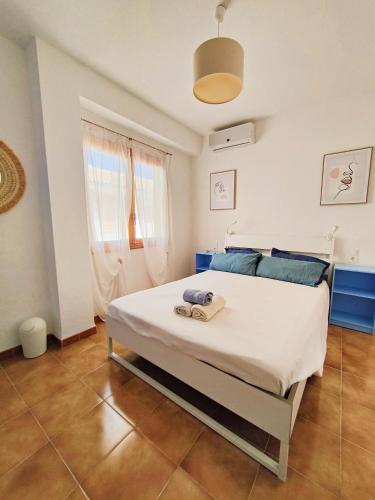a bedroom with a large white bed with blue pillows at Blue House in Santa Pola in Santa Pola
