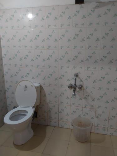 a bathroom with a toilet and a faucet at Johnson's Homestay With Pool & Ecohouseboat near town beach in Alleppey