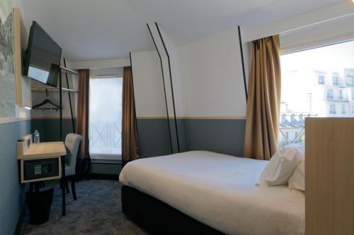 a hotel room with a bed and a desk and a window at Appia La Fayette in Paris