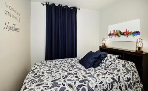 a bedroom with a bed with blue curtains at Condo 105 33 Chemin du Hameau by Les Chalets Alpins in Stoneham