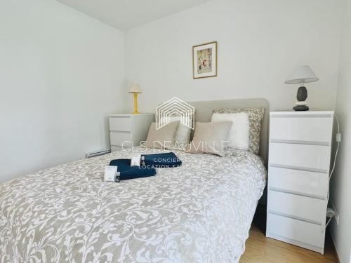 a white bedroom with a bed with a dresser at Reposant à 100 m de la mer.. C.L.S Deauville in Tourgeville