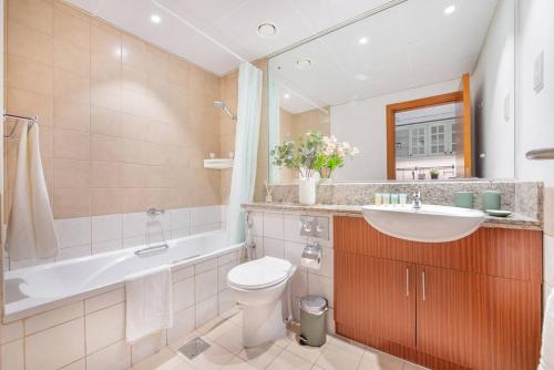 a bathroom with a sink and a toilet and a bath tub at Central studio in The Greens 10min to MetroStation in Dubai