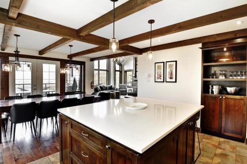 an open kitchen and dining room with wooden ceilings at Chalet 27 Chemin Blanc by Les Chalets Alpins in Stoneham
