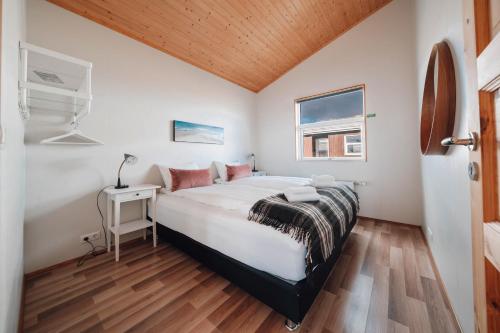 1 dormitorio con cama, escritorio y ventana en Blue View Cabin 5A With private hot tub, en Reykholt