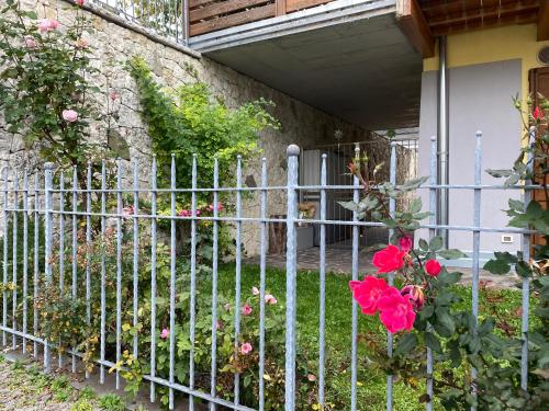 a metal fence with roses in front of a house at APPARTAMENTO ELISA in Levico Terme