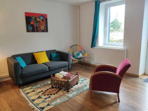 a living room with a couch and a table at Le nid d'Eugénie in Blaudeix