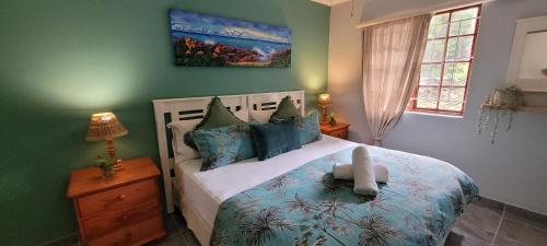 a bedroom with a bed with blue and green walls at 3 Lagoon Getaways in Southbroom