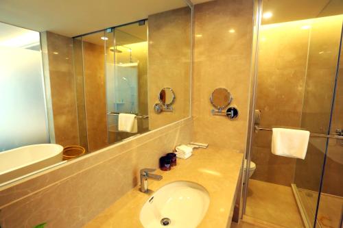 bagno con lavandino e doccia di Shenzhen Baoan PLUS Gems Cube Hotel a Bao'an