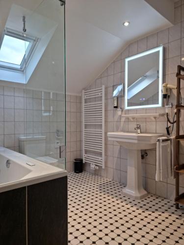 ein Badezimmer mit einem Waschbecken, einer Badewanne und einer Dusche in der Unterkunft Hotel Nassauer Hof in Limburg an der Lahn