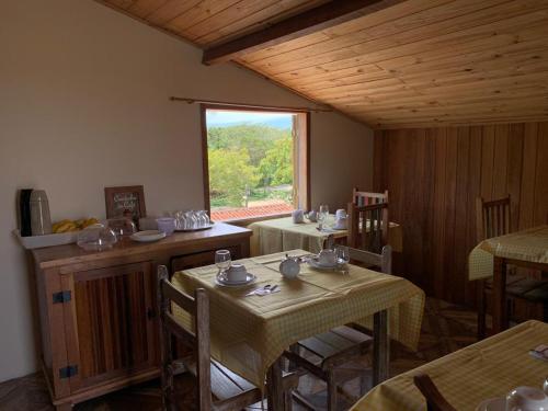 a dining room with two tables and a window at Astral de Minas in Tiradentes