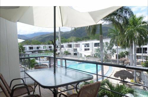 a balcony with a table and chairs and a swimming pool at Apartasol in Santa Fe de Antioquia