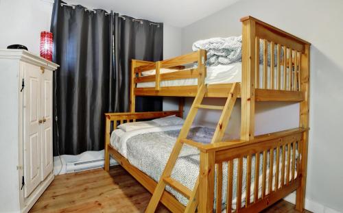 - une chambre avec 2 lits superposés et une échelle dans l'établissement Chalet 9008 Chemin des Alpages by Chalets Alpins, à Stoneham