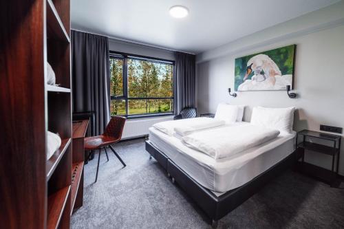 - une chambre avec un lit, un bureau et une fenêtre dans l'établissement Blue Hotel Fagrilundur - On The Golden Circle, à Reykholt