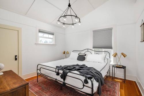 - une chambre avec un lit et un lustre dans l'établissement Garrett Retreat, à Vancouver