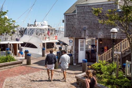 a group of people walking around a marina at The Cottages & Lofts in Nantucket