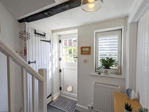a hallway with a white door and a window at Baytree Cottage, Walberton in Walberton
