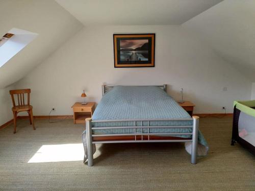 une chambre avec un lit et un tableau au mur dans l'établissement Maison de famille entre terre et mer, à Lantic