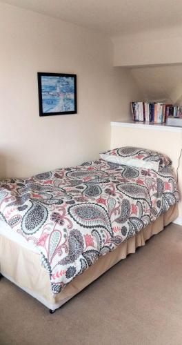 a bedroom with a bed with a colorful blanket at 26 Castle Street in Kirkcudbright