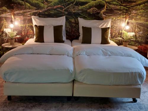 two beds sitting next to each other in a bedroom at Bed en Breakfast Het Oelenest in Hooghalen