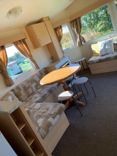 a living room with a table and a couch at Loch Heron View in Newton Stewart