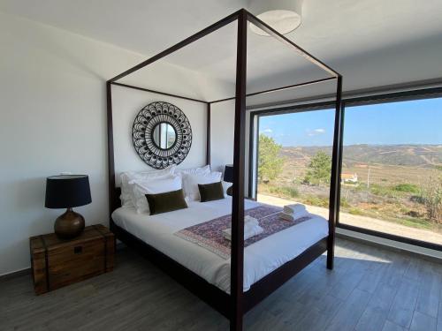 1 dormitorio con cama con dosel y ventana grande en Cairnvillas - Villa Mar C38 Luxury Villa with Private Swimming Pool near Beach en Aljezur