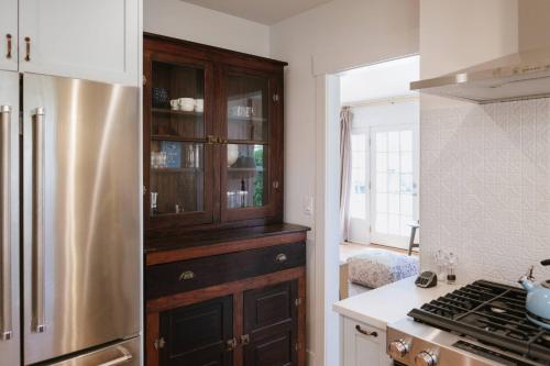 a kitchen with a wooden cabinet and a refrigerator at Vine and View Bungalow in Newberg