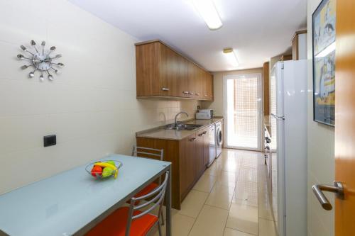a kitchen with a counter and a sink and a refrigerator at SOLIMAR 10 SALOU Solo FAMILIAS con Parking y piscina in Salou