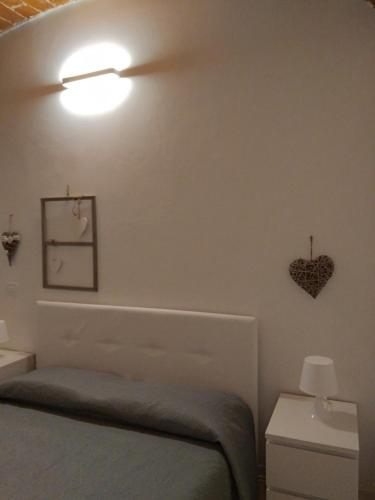 1 dormitorio con 1 cama y un corazón en la pared en Gioberti, en Casale Monferrato