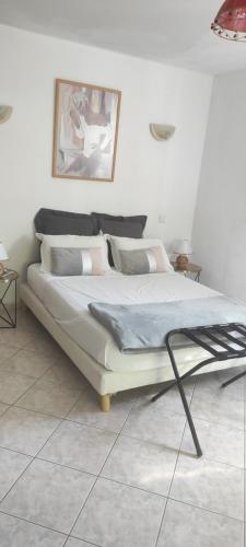 Łóżko w białym pokoju z: w obiekcie Belle maison de charme ancien, vue mer et montagne w mieście Casalabriva