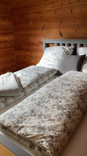 RuppichterothにあるGemütliches Holzhaus in idyllischer Lageの木製の壁の客室内のベッド2台