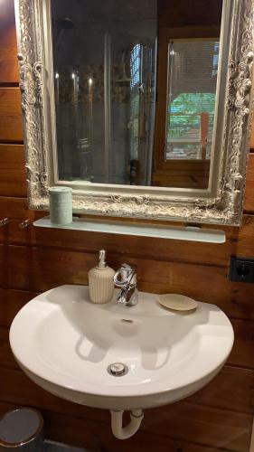 a white sink in a bathroom with a mirror at Gemütliches Holzhaus in idyllischer Lage in Ruppichteroth