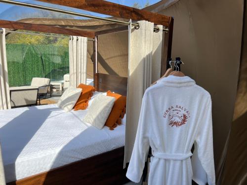 a bedroom with a bed and a sweater on a rack at Sierra Salvada Bubbles in Salmantón