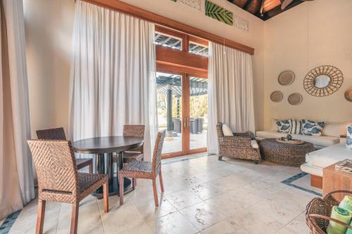 a living room with a table and chairs and a couch at Fabulous villa with picuzzi at Green Village B843 in Punta Cana