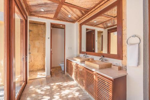 a bathroom with two sinks and two mirrors at Fabulous villa with picuzzi at Green Village B843 in Punta Cana