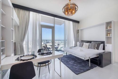 a white bedroom with a bed and a table and chairs at Breathtaking view compact & modern spacious studio in Dubai