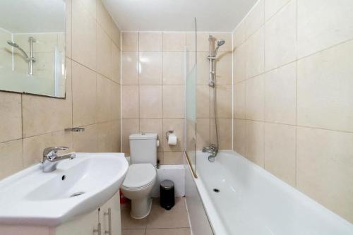 een badkamer met een wastafel, een toilet en een bad bij (Kensington Museum) 2 bedroom apartment London in Londen