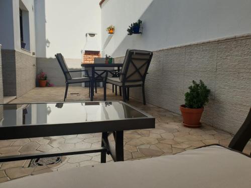 un patio con 2 sillas, una mesa y una mesa en La Casona de Alba, en Encinasola