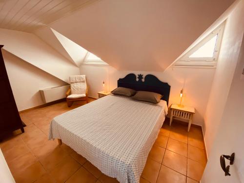 - une chambre mansardée avec un lit blanc dans l'établissement Tucum Home - Appart au Village Vacances Sainte Anne, à Sainte-Anne