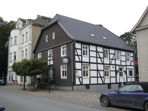 ein Schwarz-Weiß-Gebäude an der Straßenseite in der Unterkunft Hotel Pemü in Arnsberg
