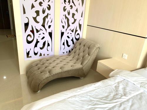 a bed room with a bench in a bedroom at Wiwi Formosa Residence Nagoya Batam in Nagoya