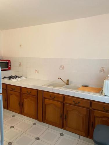 a kitchen with a sink and a stove at Charmant logement situé à Sainte-Anne in Sainte-Anne